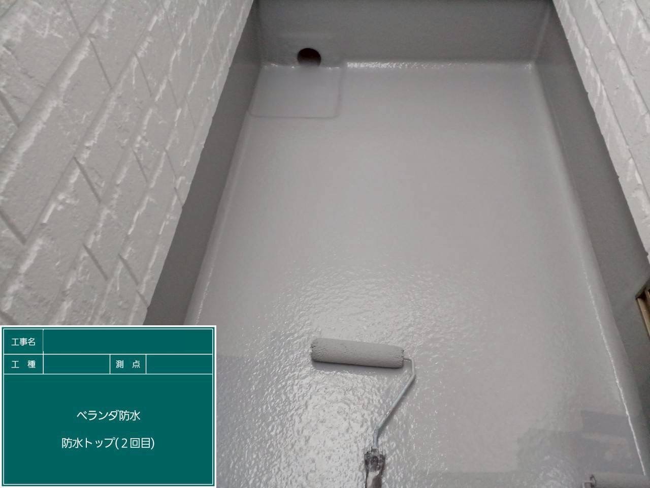 2回目のトップコートを塗装中のバルコニー床